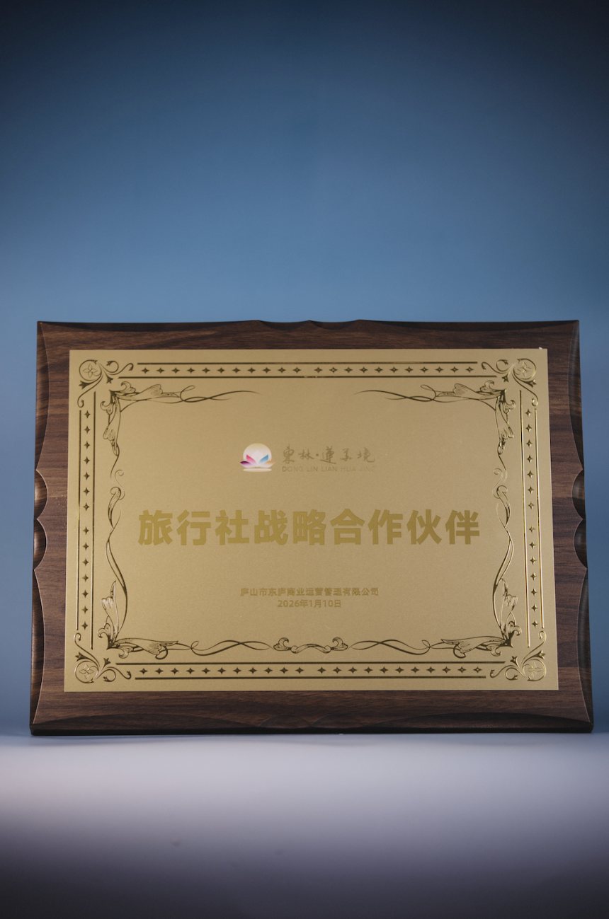Donglin Lianhuajing 2026 Travel Agency Strategic Cooperation Partner gold-and-walnut wooden plaque, dated 10 Jan 2026, presented to Jiangxi Heyi International Travel
