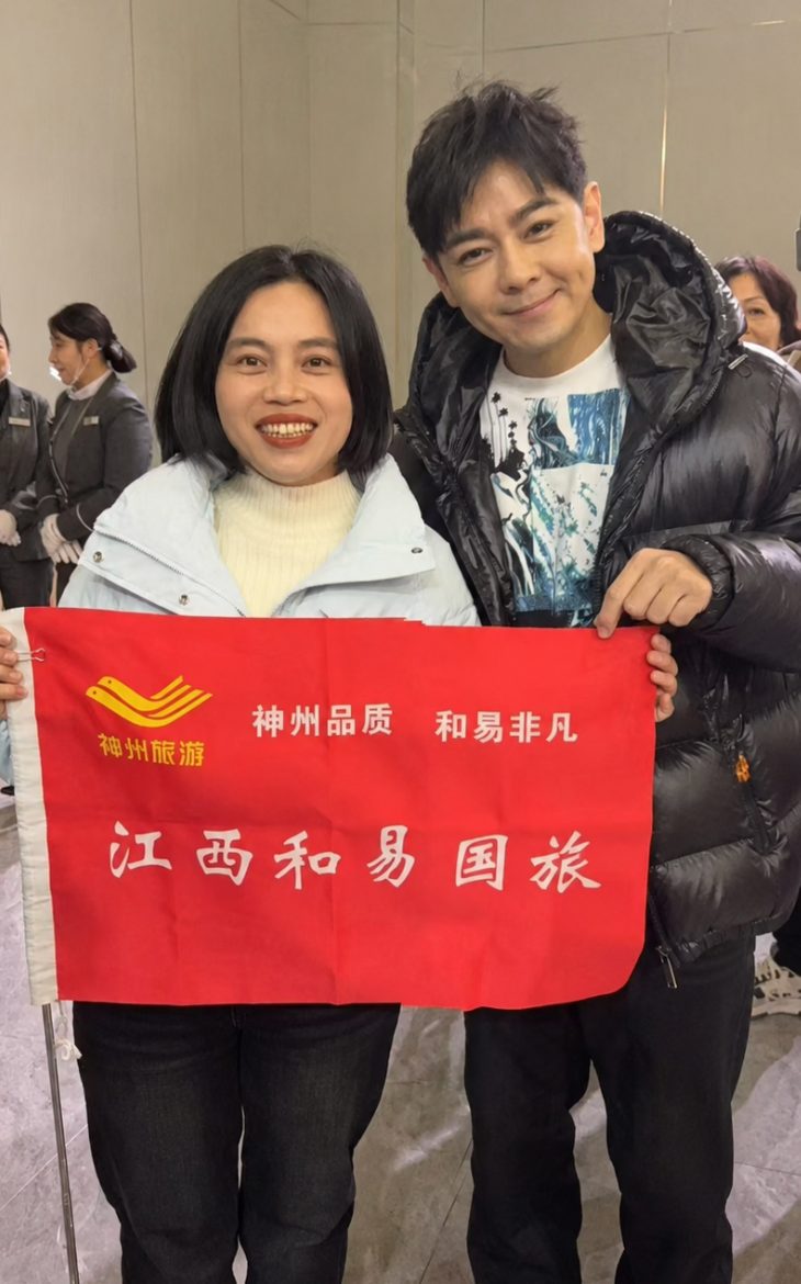 HeartEase guide Chen Jie with traveler Lin Zhiying, holding the Jiangxi HeartEase banner in Nanchang